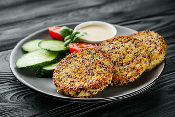 quinoa cutlet with vegetables on a black wooden rustic background