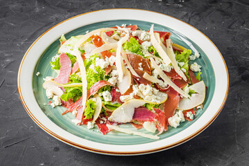 prosciutto salad with parmesan pear and blue cheese on a black background