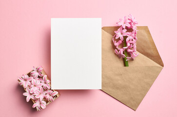 Invitation or greeting card mockup with envelope and spring hyacinth flowers on pink background