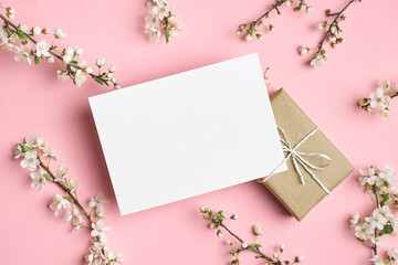 Greeting card mockup with gift box and flowers on pink