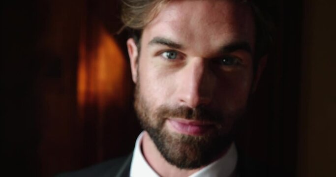 Young bearded man looks at the camera, preparing for wedding