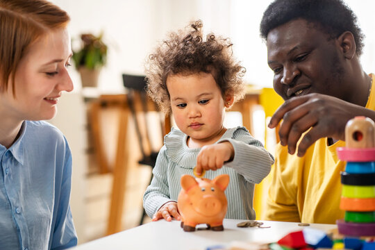 Kid inserting a coin into a piggy bank, financial concept. Kid saving money for future concept.