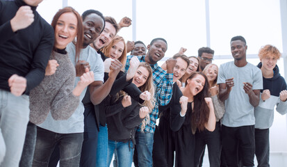group of diverse young people are applauding while looking at you