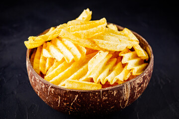 golden crispy potato chips on a dark background