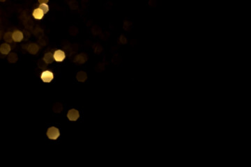Golden blurred bokeh lights on black background. Glitter sparkle stars for celebrate. Overlay for...