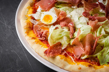 hot delicious traditional italian pizza on a dark stone background