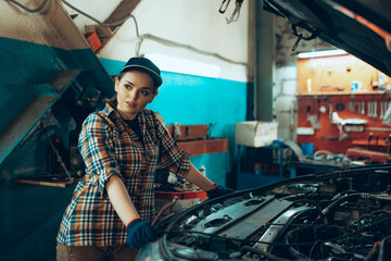 Car reapir, exam. Young pretty girl, auto mechanic working at auto service station using different...