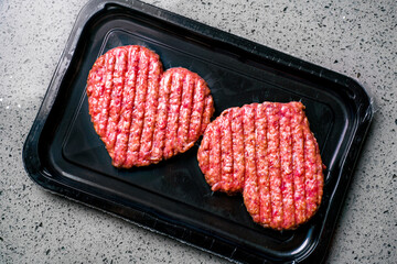 Dinner for lovers on February 14. Vacuum pack of two cutlets. Valentine's Day. Meat cutlet in the shape of a heart. Meat love