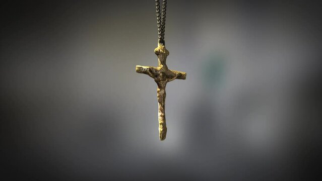 High quality close up render of a beautiful antique gold Christian Crucifix artifact swinging slowly on the end of a neck chain, with super shallow depth of field abd bokeh background
