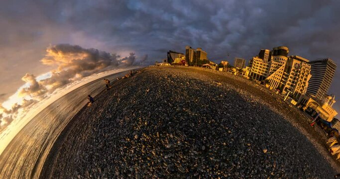 abstract folding of the earth plane into tiny planet in evening sky with clouds on seashore with skyscrapers. Little planet transformation with curvature of space with loop rotate