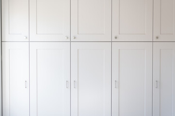 Modern new fitted tall cupboards in kitchen light grey color, interior trendy units. Huge storage...