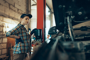 Destroying gender stereotypes. Young woman auto mechanic working at auto service station using different work tools. Gender equality. Work, occupation, car