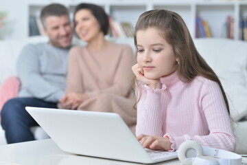 Happy girl  sitting at table with laptop