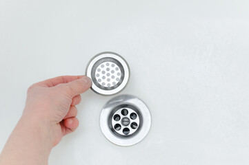 Metal filter hand. Drain hole in the bathroom. - obrazy, fototapety, plakaty