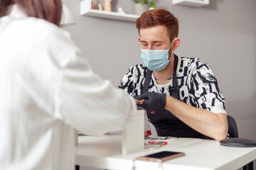 Nail master working on client nails at beauty center