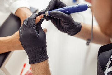 Professional manicure master working on nails in salon