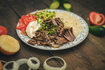 doner or shawarma called pilav ustu on rice, with yogurt , tomatoes and herbs