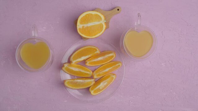 Glass of orange juice with oranges top view, amaranth pink background. Flat lay. Love for fruits, healthy food