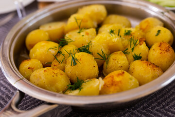 Naklejka na ściany i meble toasted young potatoes with dill in metal skillet