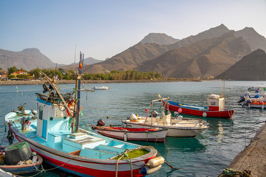 View of colourful boats in harbour and mountains in background, Puerto de La Aldea, Gran Canaria, Canary Islands