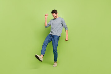Full body photo of handsome young man have fun enjoy his hobby dancing isolated on green color...