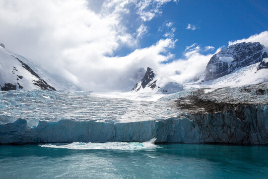 A view of snow-capped mountains and a shooter from the glacier in Drygalski Fjord, South Georgia