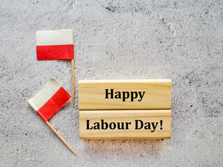 Happy Labour Day written on Wooden Blocks with Polish Flags 