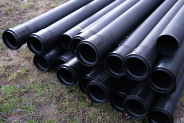 lot of new black pipes for protecting electrical wires lie on the ground, concept of repairing...