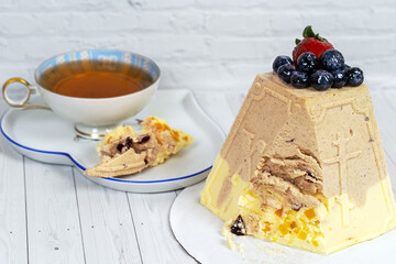 Easter cake from cottage cheese, on white background, close to cup of tea. Wooden white background, soft selective focus, copy space.