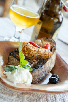 Greek appetizer of stuffed zucchini flowers served with bruschetta and tzatziki sauce in wood bowl, Crete, Greek Islands
