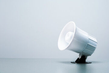White megaphone or siren sound on grey background with copy space.