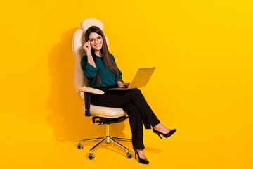 Full length profile side photo of young cheerful lady use laptop manager boss sit stool isolated...
