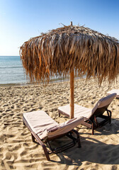 Fototapeta na wymiar Sun loungers under beach sunshade