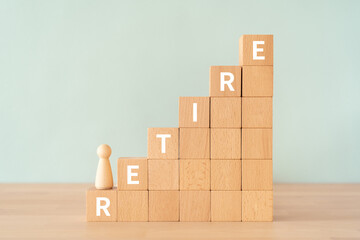 退職・引退のイメージ｜「RETIRE」と書かれた積み木と人形