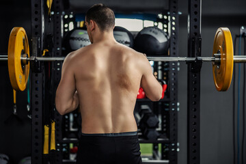 Back shot of a shirtless man in good visual and physical shape. 