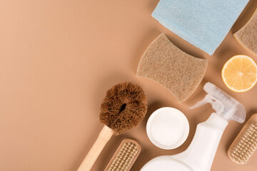 Organic household cleaners for green household - bamboo brush, organic dishcloth, lemon, baking soda, citric acid, spray bottle on beige background with copy space. Mockup, flat lay