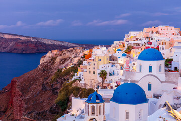 Blue domed white church and colourful buildings at sunrise, Oia, Santorini, Cyclades, Greek Islands
