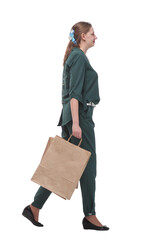 Full length side view of happy young woman walking with shopping bags