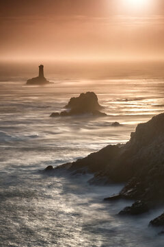 Pointe du Raz lighthouse and cliffs at sunset in Finisterre, Brittany, France