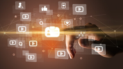 Naklejka premium Hand pressing social media multimedia application screen with media icons on futuristic concept