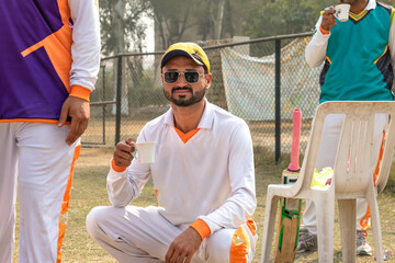  young cricketer holding teacup on hand on match ground