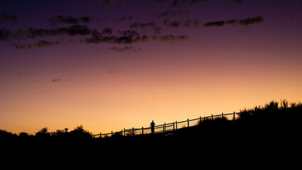 Obraz na płótnie Canvas a distant Human Silhouette at sunset