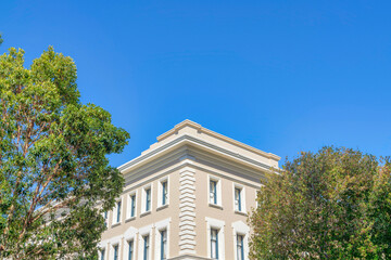 Corner part of a beige building against the clear sky background in San Francisco, California