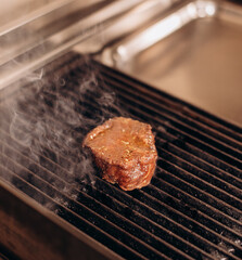 Delicious juicy raw meat steak cooking on grill.