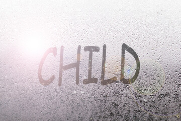 Foggy glass on window with written finger word child overcast wet window