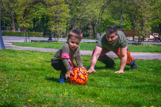 Father and son playing football in park outdoor family activities football fans supporters warming for Qatar World Cup 2022 father and son playing amateur soccer 