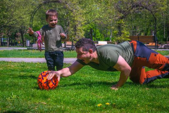 Father and son playing football in park outdoor family activities football fans supporters warming for Qatar World Cup 2022 father and son playing amateur soccer 
