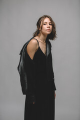 Fototapeta premium Stylish young woman in black dress and black leather jacket.