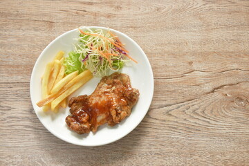 grilled chicken black pepper steak dressing spicy sauce with French fries and salad on plate