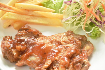 grilled chicken black pepper steak dressing spicy sauce with French fries and salad on plate